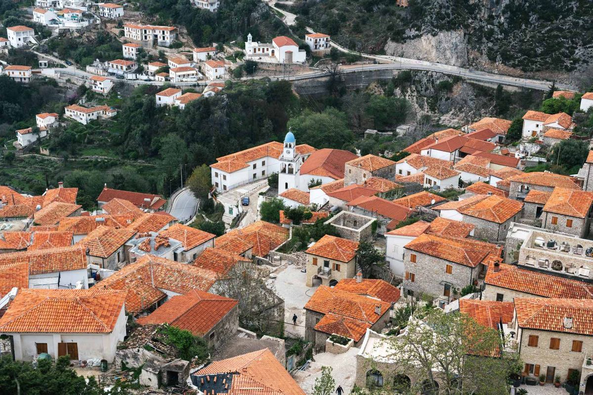 The traditional red-roofed houses of Dhërmi, nestled on the mountainside with panoramic views.