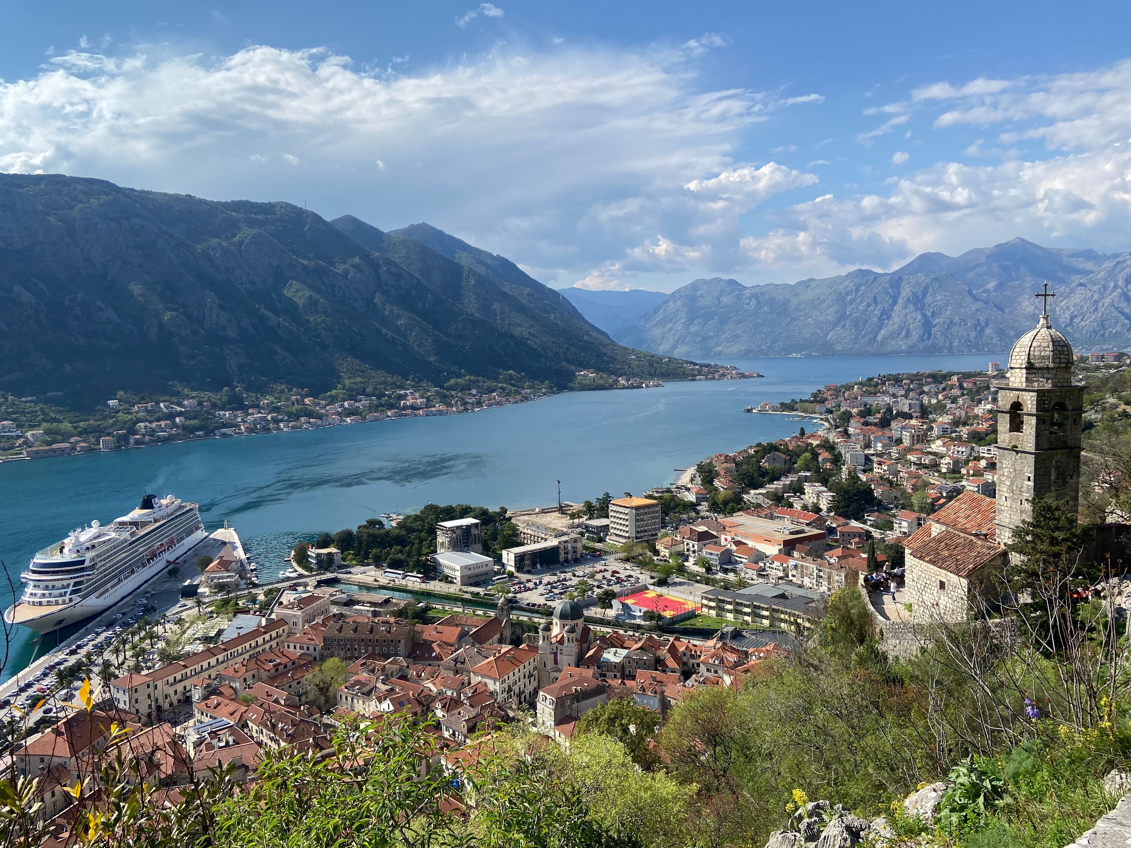 Një pamje mahnitëse e qytetit të vjetër të Kotorit, shtëpive me çati të kuqe. Një vend i përkryer për të parë magjinë e qytetit nga lart.