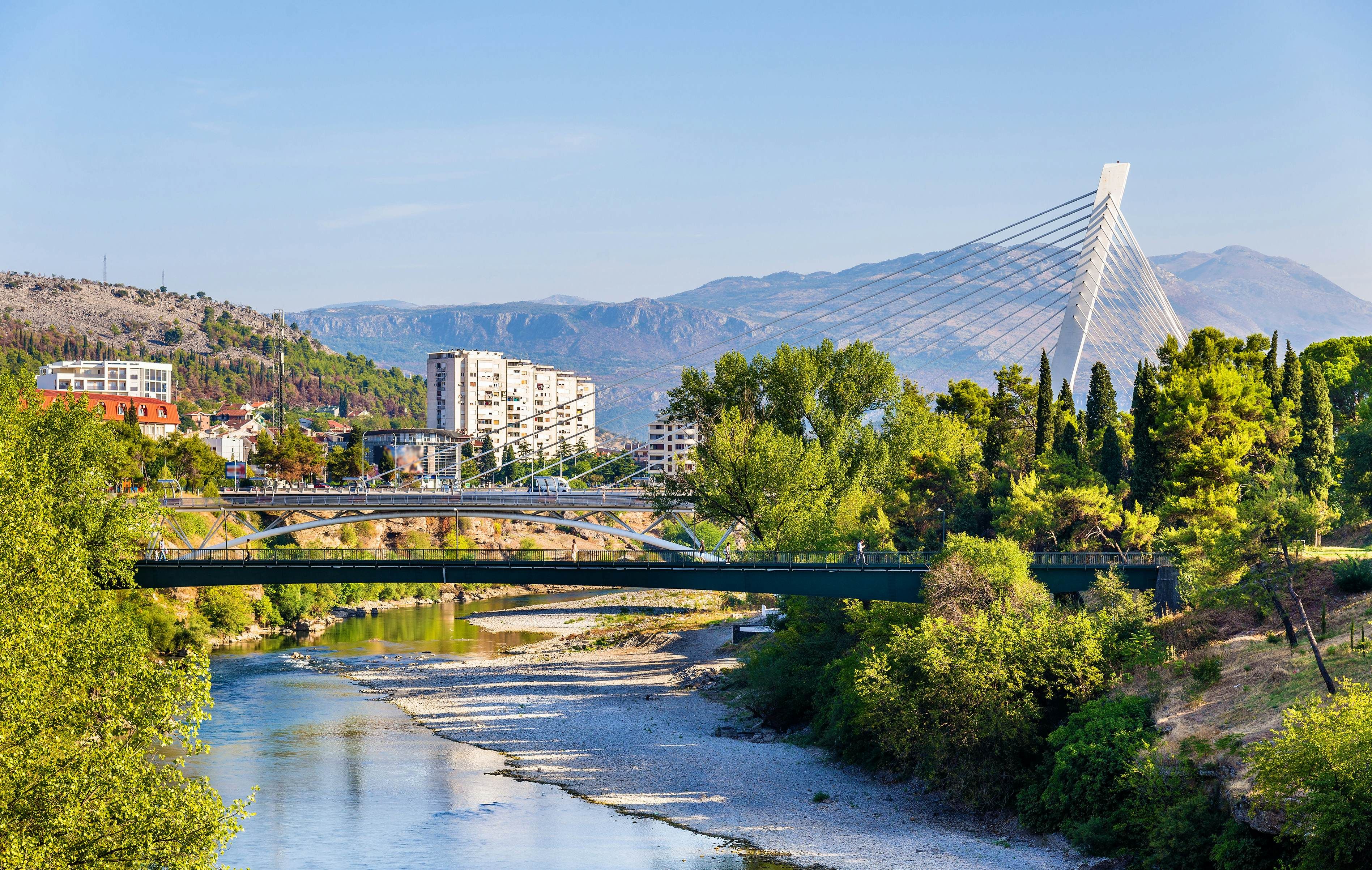 Brigjet e bukura të Podgoricës me ura moderne dhe tradicionale, të rrethuara nga gjelbërimi dhe malet.