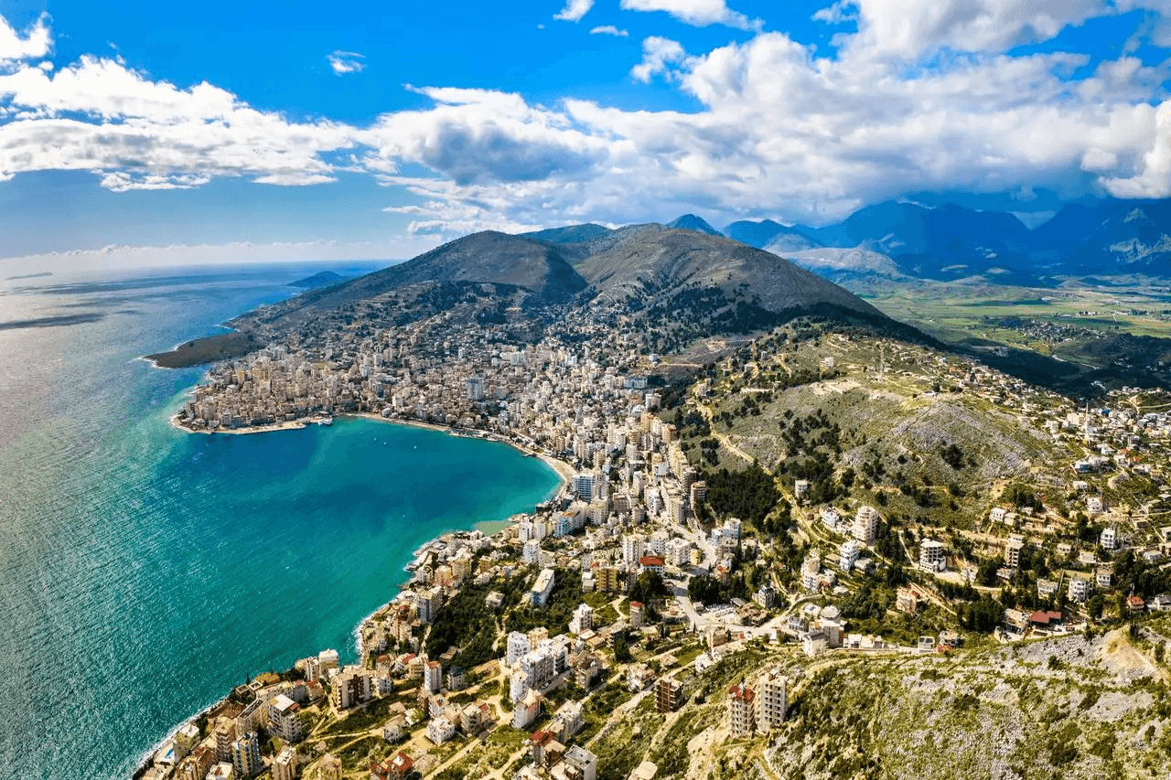 A panoramic view of Vlore, showing the coastline, mountains, and cityscape